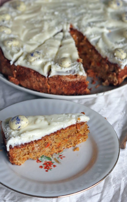 Stück Karottenkuchen mit Frischkäsetopping. Rüblitorte backen mit diesem einfachen Rezept. Perfektes Osterrezept total easy.